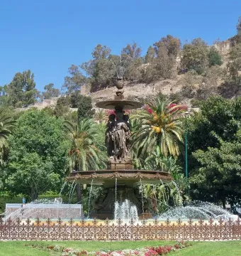 Three Graces Fountain with classical female figures and flowing water in a park