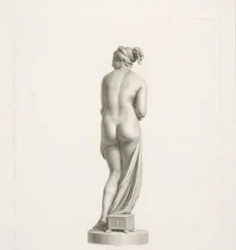 Back view of Venus Italica, a classical nude female statue standing on a circular plinth with drapery over one leg.