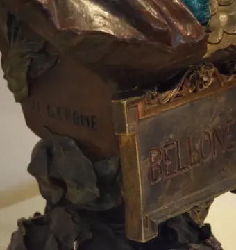 Close-up of the bronze base of Bellone by J.L. Gérôme, showing a BELLONE plaque and carved signature.