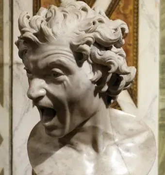 Damned Soul marble bust with a contorted face and open mouth in a scream, set on an ornate pedestal.