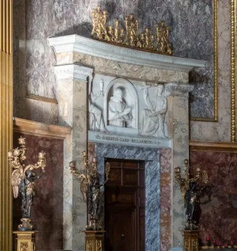 Marble altar with a relief of Saint Robert Bellarmine, flanked by angel figures and golden candelabras.