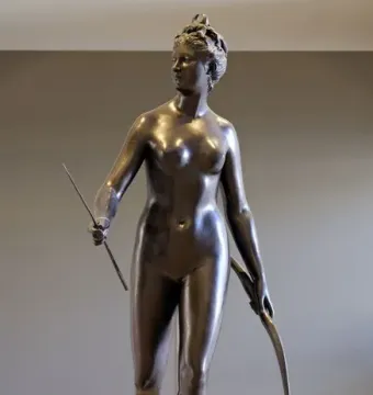 Bronze statue of Diana holding a bow and arrow in a twisting pose.