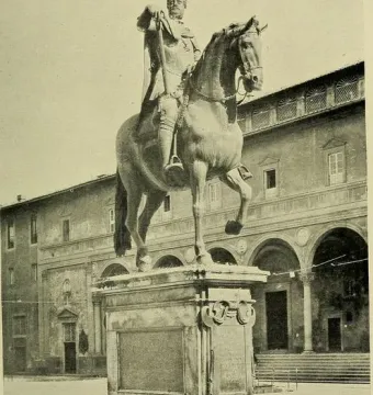 Ferdinando I de\' Medici equestrian statue on an ornate pedestal in a public square, with a large arched building behind it.