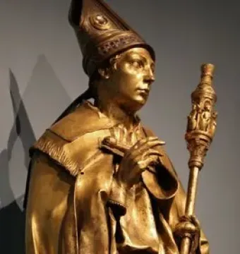 Saint Louis of Toulouse shown as a gilded standing statue holding a staff and a small book.