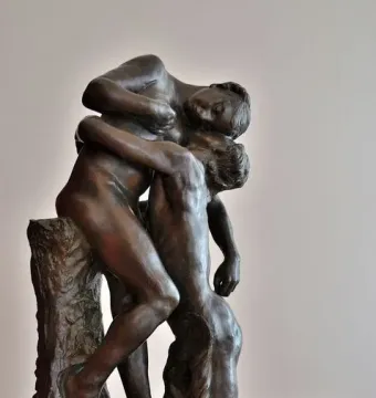 Sakuntala, a dark bronze sculpture of two nude figures in an embrace, with one standing and supporting the other kneeling.