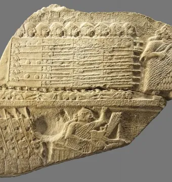 Fragment of the Stele of the Vultures showing carved figures and cuneiform inscriptions.
