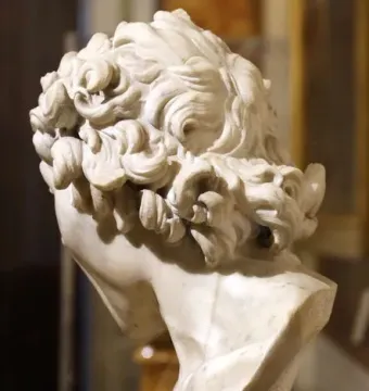 Damned Soul marble bust shown from the back and right side, with tightly curled hair and the head bowed on a marble pedestal.