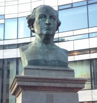 Schadow Monument with a bronze-toned sculpture of an elderly man on a tall stone plinth