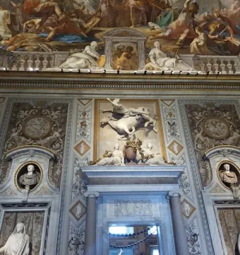 The Rape of Proserpina sculpture seen through a marble archway, with the figure of Pluto lifting Proserpina and a dog nearby.