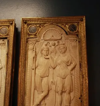 Queriniano Diptych ivory panel with carved classical figures and a winged figure in an ornate frame.