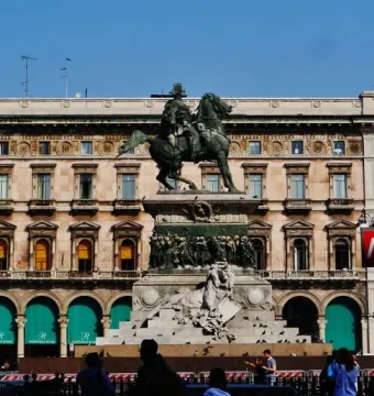 Victor Emmanuel II Monument with a bronze equestrian statue atop a marble pedestal, featuring a reclining lion sculpture and relief figures.