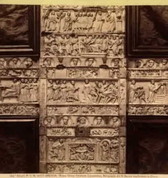 The Brescia Casket, an ivory casket with dense relief carvings arranged in horizontal panels and framed by dark wood.