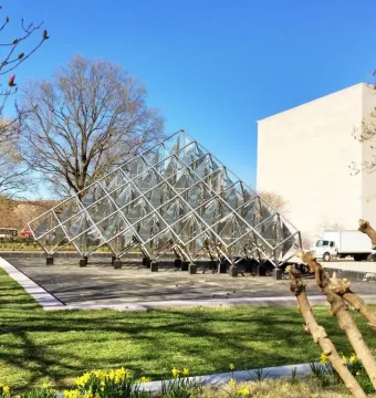 Delta Solar, a pyramid-shaped stainless steel sculpture with reflective panels in a grassy park