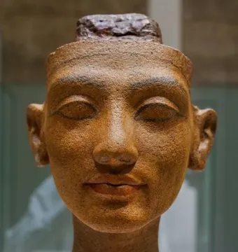 Unfinished head of Nefertiti with closed eyes and a rough top edge.