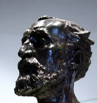 Bronze bust of Jules Dalou with a beard and sculpted hair, facing left.