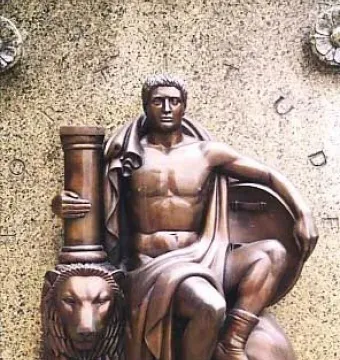 Bronze relief of a muscular seated male figure holding a column and resting on a shield with a lion base.
