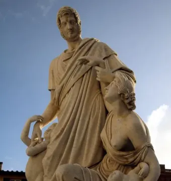Canapone sculpture with a standing bearded man in classical robes, a seated woman with a baby, and a child at his side.