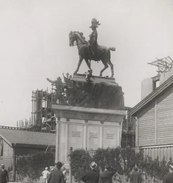 An equestrian statue of Christian IX stands newly erected as several suited onlookers gather below and look up.