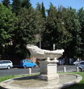 Fontana della Navicella stone boat fountain in a shallow basin beside a street