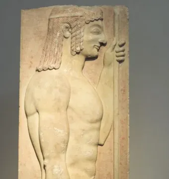 Grave stele with a relief of a youthful male figure in profile holding a staff.