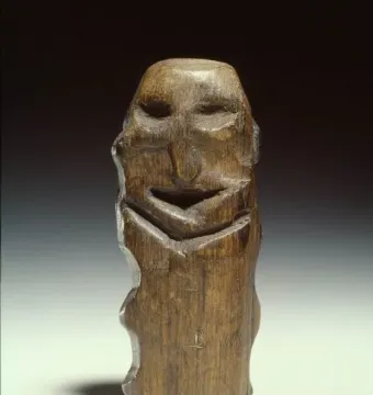 Mannetje van Willemstad wooden idol with a dark weathered surface and carved facial features.