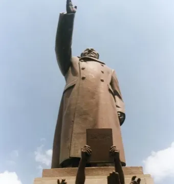 Bronze monument Long Live the Victory of Mao Zedong Thought showing a raised-arm figure above smaller bronze figures at the base