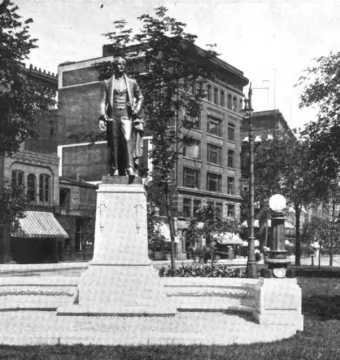 Stevens T. Mason Monument with a bronze figure on a tall stone pedestal in an urban park setting.