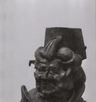 L\'antigrazioso, a dark textured abstract bust sculpture on a wooden base and pedestal.