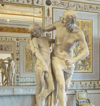 Daedalus and Icarus marble sculpture showing two standing male figures in an ornate gilded room.