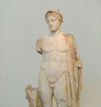 Hermes Criophorus marble statue of a nude male figure with a cap, a draped cloth over one shoulder, and a ram beside his leg.