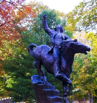 Israel Putnam Equestrian Statue showing a rider on horseback with a raised fist, framed by autumn trees.