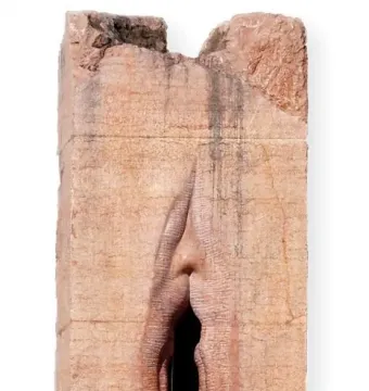 Pi-Chacán stone sculpture with a vertical vulva-like opening and subtle facial features at the top.