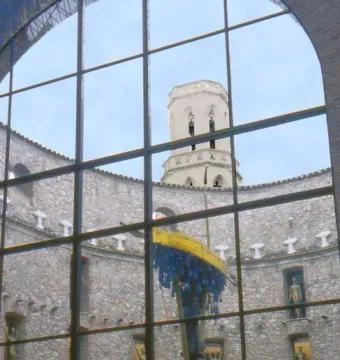 Rainy Taxi sculpture visible through an arched window at the Dalí Theatre-Museum in Figueres, with a yellow boat and blue hanging strands.