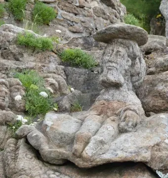 Rothéneuf Sculpted Rocks showing a bearded man carved into granite with a flat hat.