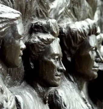 Close-up of a bronze relief on the Kate Sheppard National Memorial showing several women’s faces in profile.