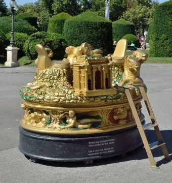 The Cellini Salt Cellar, a large ornate golden sculpture with many figures and a central architectural form on a dark base.