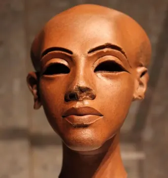 Head of a Princess, a reddish-brown stone sculpture with a slender neck, dark almond-shaped eyes, arched brows, and damaged nose bridge.