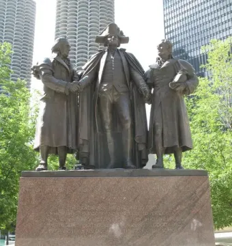 Heald Square Monument bronze sculpture with George Washington and two men in period dress, set on a granite pedestal in downtown Chicago.