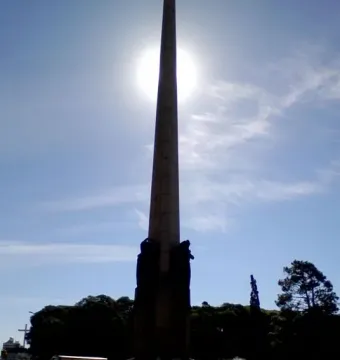 Obelisk of Montevideo silhouetted against the sun with a fountain spraying at its base