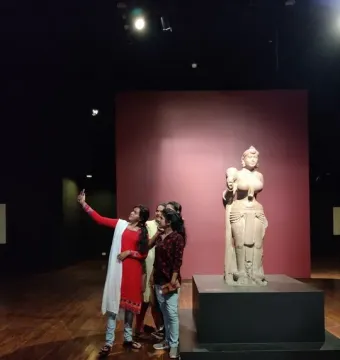 Didarganj Yakshi stone sculpture standing on a pedestal, with a broken left hand and jewelry details.