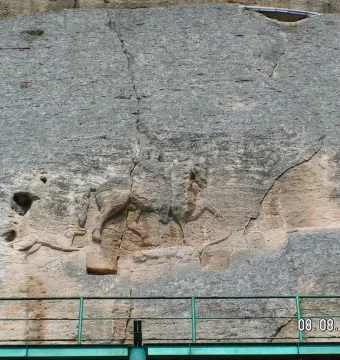 Madara Rider rock relief carved into a weathered cliff face, showing a mounted figure above a faint lion carving.