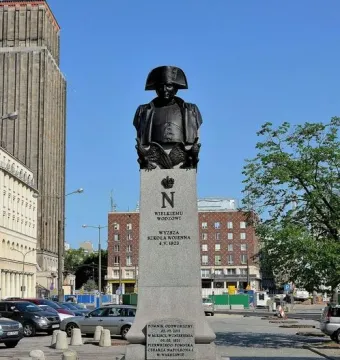 Napoleon Bonaparte monument in Warsaw, showing a bronze bust on a tall stone plinth.