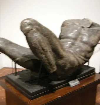 River God sculpture showing a large muscular male torso lying horizontally on a dark base.