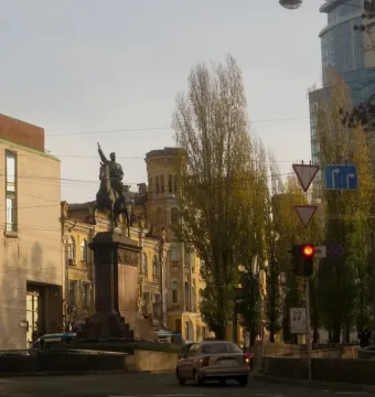 The Monument to Mykola Shchors, an equestrian statue on a tiered stone pedestal at a city intersection.