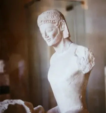 Fragmentary marble head and upper body of the Rampin Rider with an archaic smile, beard, and detailed hair.