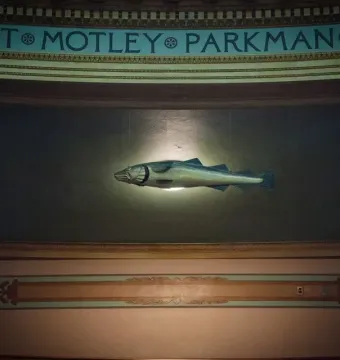 The Sacred Cod sculpture suspended between ornate pillars in the Massachusetts State House chamber.