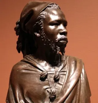 The Nubian Man, a dark bronze bust of a man wearing a draped garment and wrapped headcloth.