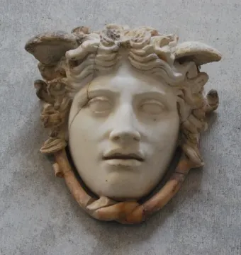 Medusa Rondanini marble face with curly hair-like elements, downcast eyes, and visible cracks in the stone.