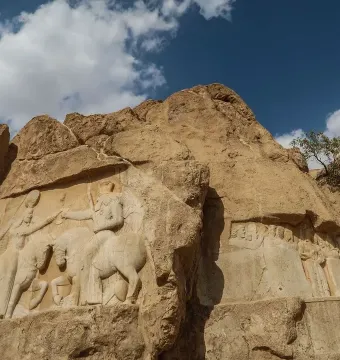 Ardashir Investiture Relief carved into a cliff, showing two mounted figures in a ceremonial exchange with smaller figures below.