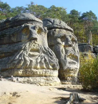 The Devil\'s Heads sandstone carvings, with two massive carved faces in a forest setting.